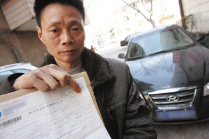 老胡拿着没有保单号的假保单,到昆明找律师求助 记者 韩亿国/摄
