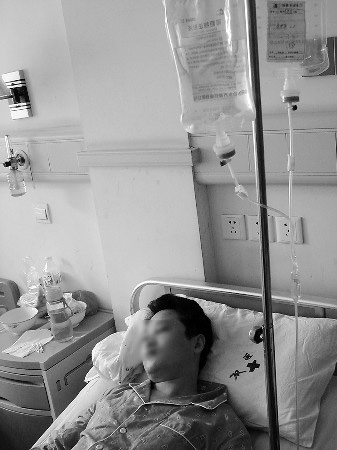 13日，被打伤的李先生仍躺在病床上接受治疗。 本报记者 刘铭 摄