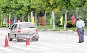 轿车飞驰而去,后面是被撞坏的隔离桩
